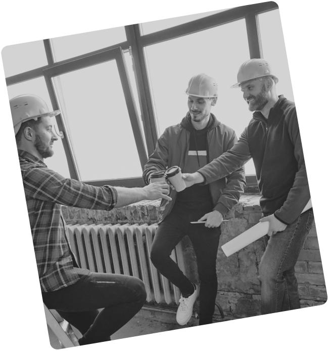 three men wearing hardhats and toasting with their coffee cups